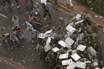 Supporters of ousted Honduras' President Manuel Zelaya clash with soldiers near the presidential residency Tegucigalpa, Monday, June 29. 2009. Police fired tear gas to hold back thousands of Hondurans outside the occupied presidential residency as world leaders from Barack Obama to Hugo Chavez appealed to Honduras to reverse a coup that ousted the president, Manuel Zelaya. (AP Photo/Esteban Felix)